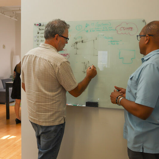 two men at whiteboard